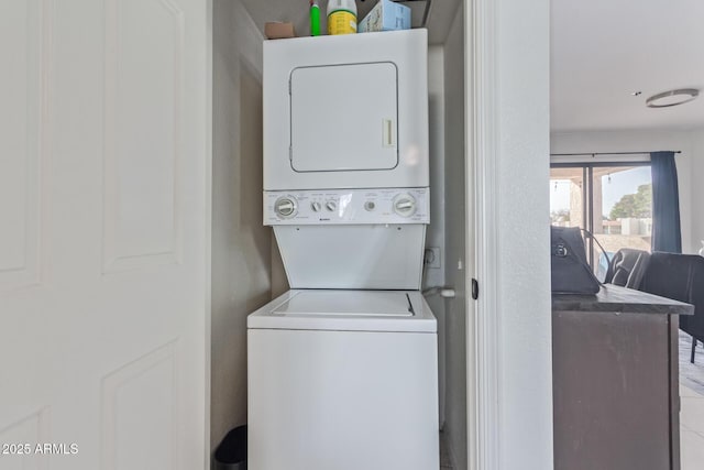 clothes washing area featuring stacked washer / dryer