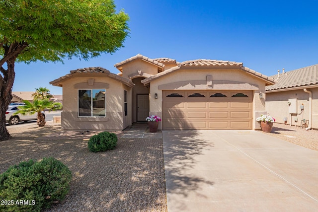 mediterranean / spanish-style home with driveway, stucco siding, an attached garage, and a tile roof