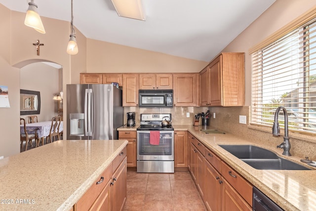 kitchen featuring backsplash, light stone countertops, a sink, and appliances with stainless steel finishes