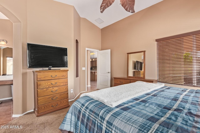 bedroom featuring baseboards, high vaulted ceiling, arched walkways, and carpet