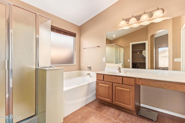 full bath with a shower stall, vanity, tile patterned floors, a garden tub, and lofted ceiling