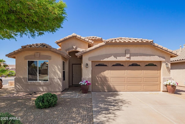 mediterranean / spanish house featuring driveway, a garage, stucco siding, and a tiled roof