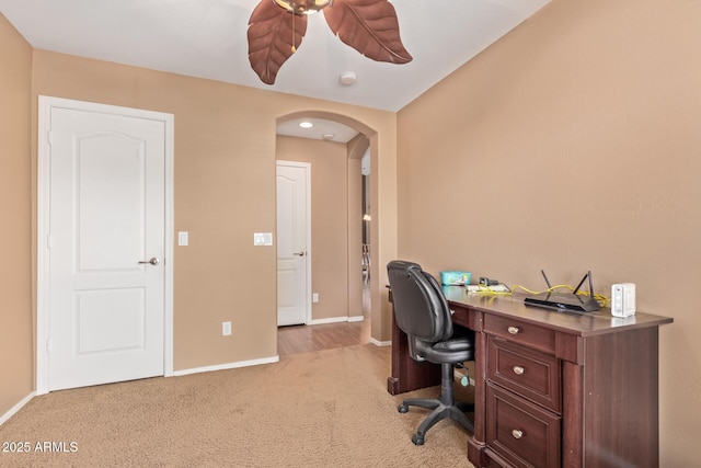 office with arched walkways, ceiling fan, carpet floors, and baseboards