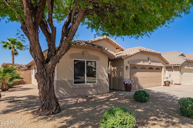 view of front of property featuring concrete driveway, a garage, stucco siding, and a tiled roof