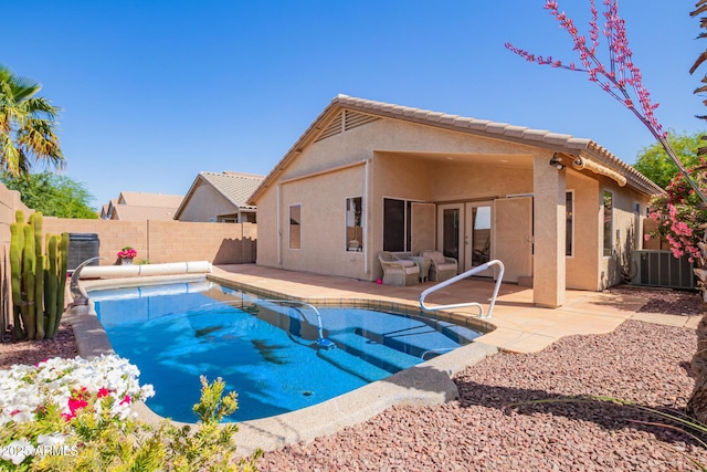 view of pool with a patio, a fenced backyard, central AC unit, and a fenced in pool