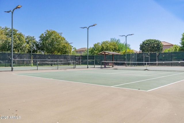 view of tennis court with fence and community basketball court