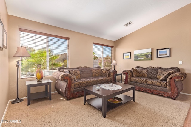 living room featuring lofted ceiling, light colored carpet, visible vents, and baseboards