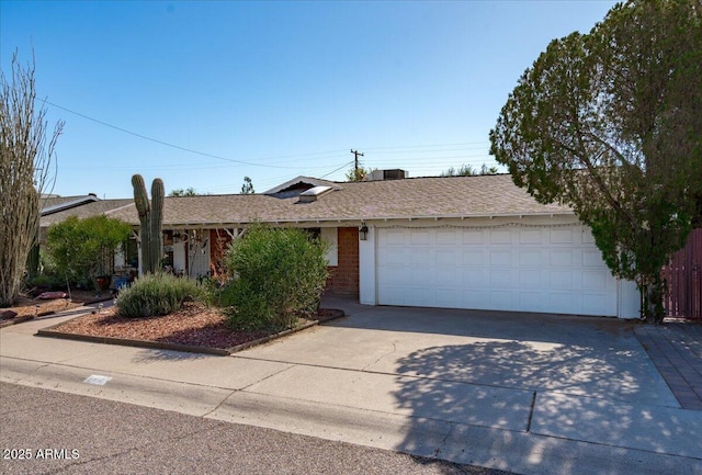 single story home with a garage, concrete driveway, brick siding, and a shingled roof