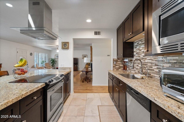 kitchen featuring extractor fan, sink, dark brown cabinets, stainless steel appliances, and light stone countertops