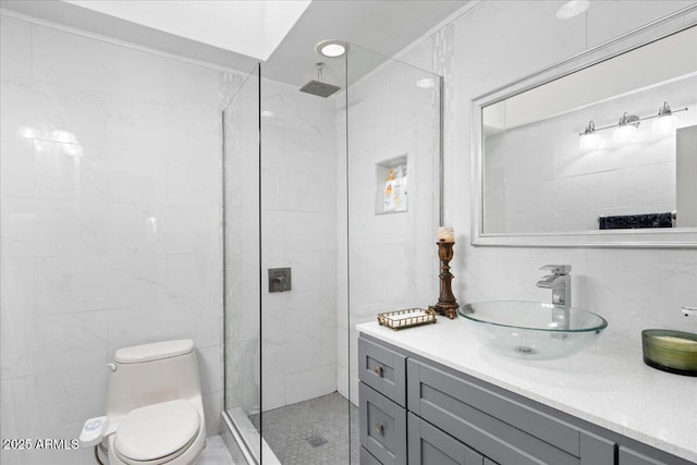 bathroom with toilet, tile walls, a tile shower, vanity, and decorative backsplash