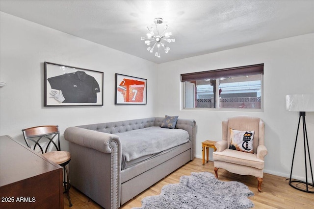 bedroom featuring an inviting chandelier and light hardwood / wood-style flooring