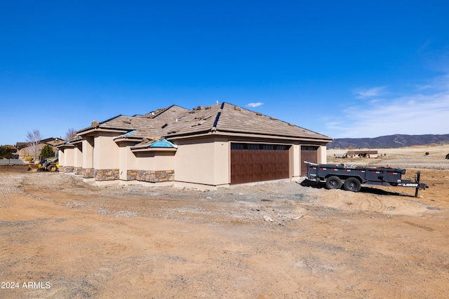 view of side of property featuring a mountain view and a garage