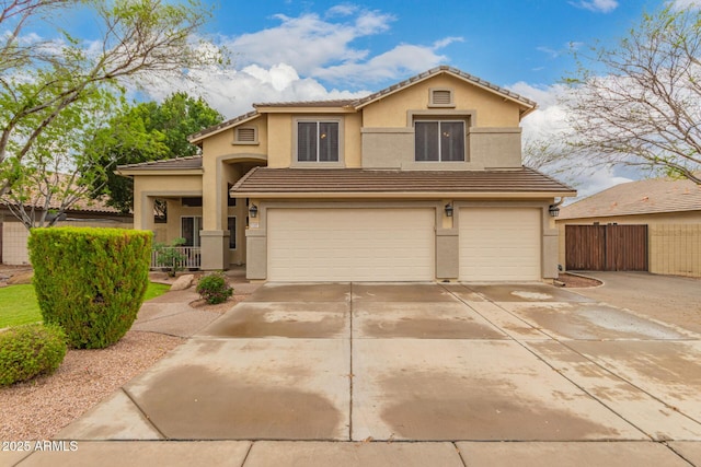 traditional-style house with a garage, fence, a tile roof, concrete driveway, and stucco siding