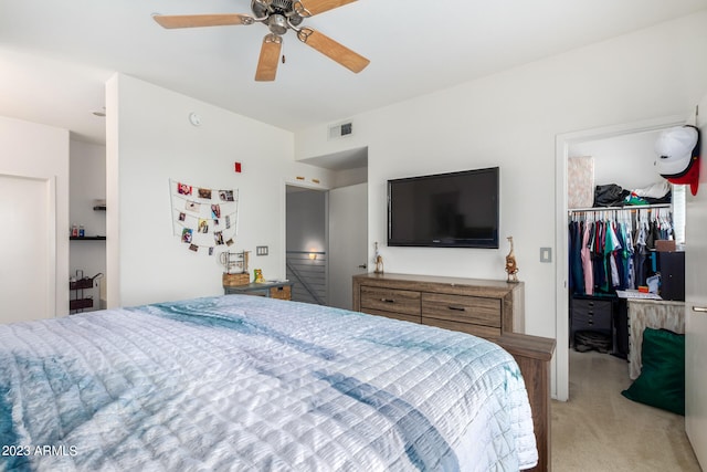 carpeted bedroom featuring a walk in closet, ceiling fan, and a closet