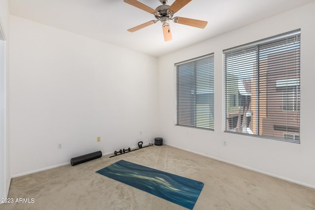 carpeted spare room featuring ceiling fan and a healthy amount of sunlight