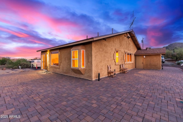 43911 N 13th Ave, New River, AZ 85087 - back of property at dusk featuring a patio and stucco siding