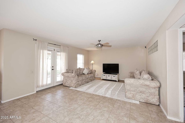 living room with ceiling fan, light tile patterned flooring, and baseboards