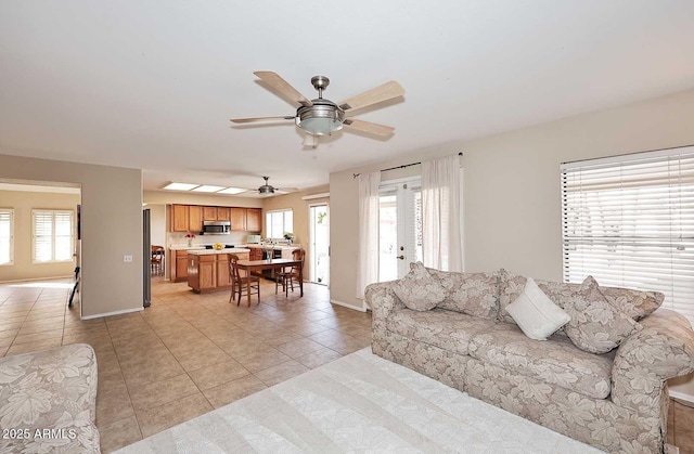 living area with plenty of natural light, light tile patterned flooring, and baseboards