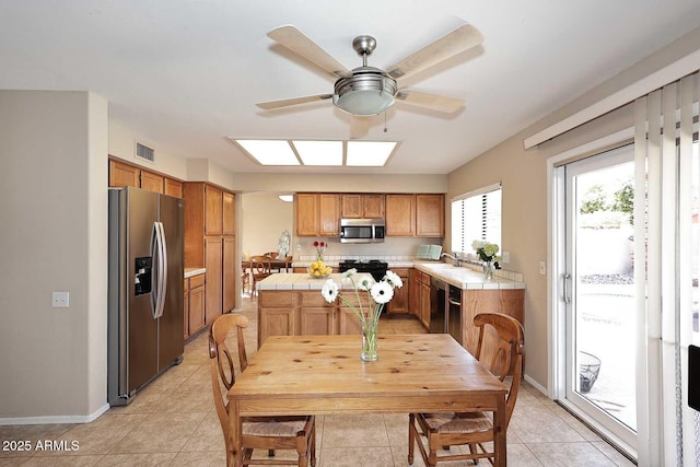 dining room with ceiling fan, visible vents, baseboards, and light tile patterned flooring