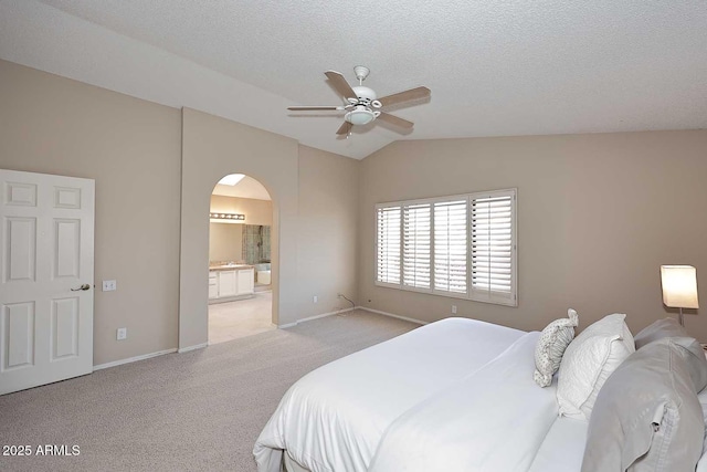 bedroom with arched walkways, a textured ceiling, lofted ceiling, light carpet, and baseboards