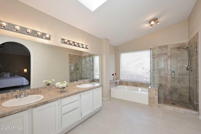 bathroom with vaulted ceiling with skylight, a sink, a shower stall, and a bath