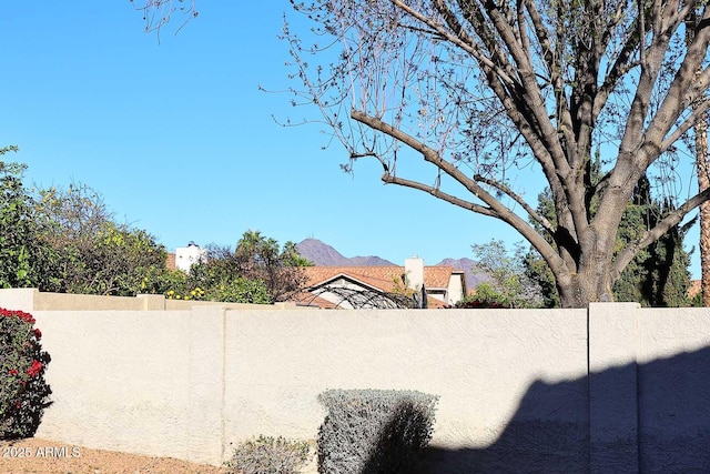 view of yard featuring fence and a mountain view