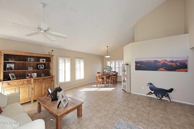 living room with a textured ceiling, light tile patterned flooring, a ceiling fan, and baseboards