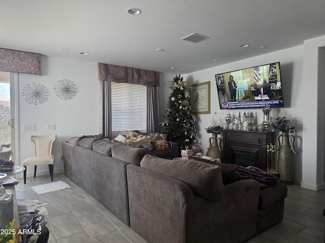 living room with recessed lighting, visible vents, baseboards, and a fireplace