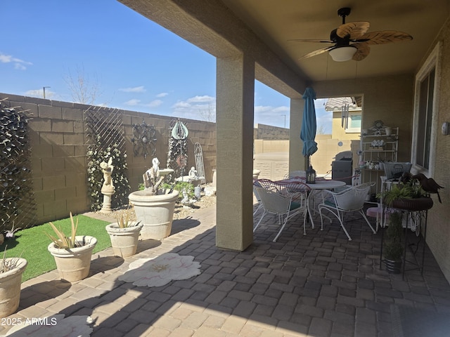 view of patio with a fenced backyard, outdoor dining space, and a ceiling fan