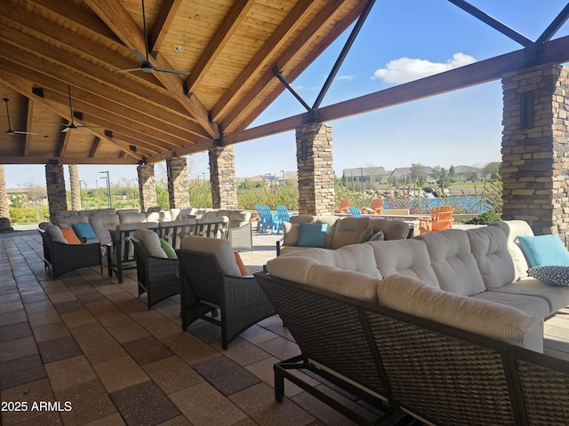 view of patio / terrace with glass enclosure, an outdoor living space, and a ceiling fan