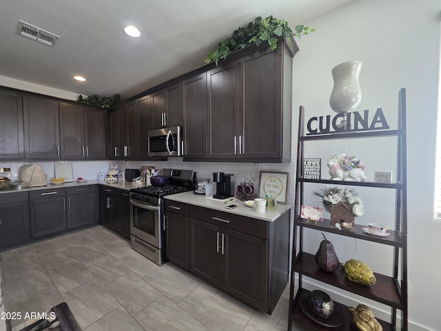 kitchen featuring visible vents, backsplash, appliances with stainless steel finishes, and light countertops