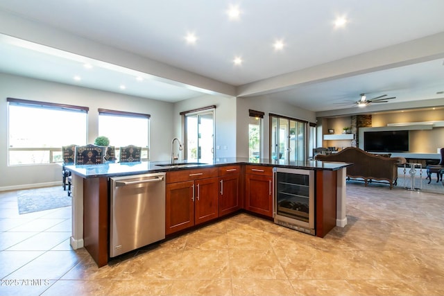 kitchen featuring plenty of natural light, beverage cooler, open floor plan, stainless steel dishwasher, and a sink