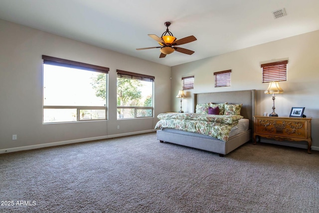 carpeted bedroom featuring a ceiling fan, visible vents, and baseboards