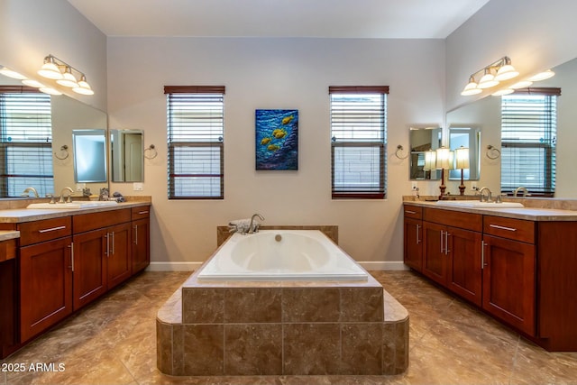 full bathroom with two vanities, a sink, and a bath