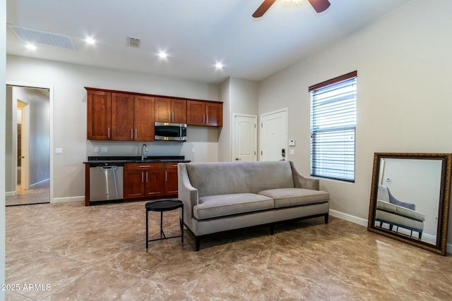 kitchen featuring appliances with stainless steel finishes, dark countertops, a sink, and visible vents