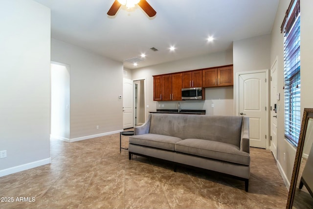 living room featuring visible vents, baseboards, a ceiling fan, and recessed lighting