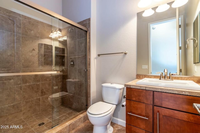 bathroom featuring a stall shower, vanity, and toilet