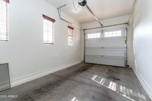 garage featuring a garage door opener and baseboards