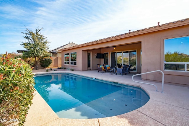 view of swimming pool with a ceiling fan, a fenced in pool, and a patio