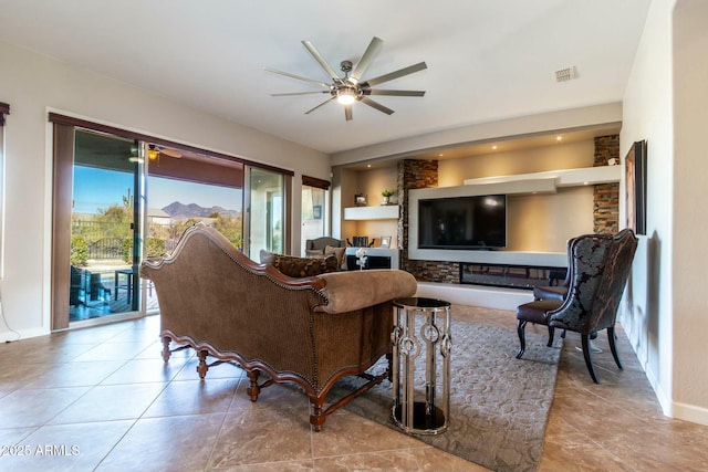 tiled living area featuring ceiling fan, visible vents, and baseboards