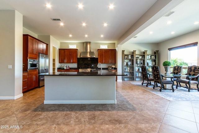 kitchen featuring appliances with stainless steel finishes, dark countertops, visible vents, and wall chimney range hood