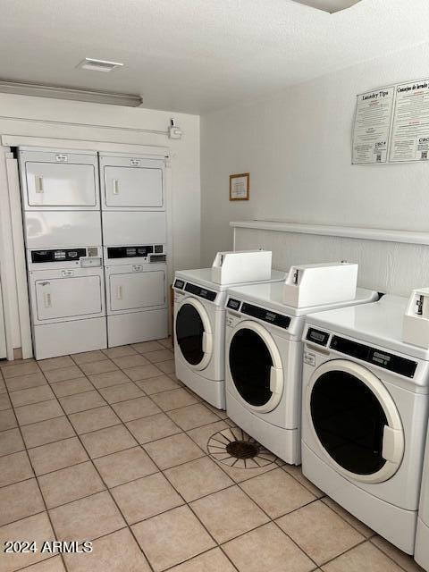 washroom with light tile patterned flooring, separate washer and dryer, and stacked washer and dryer