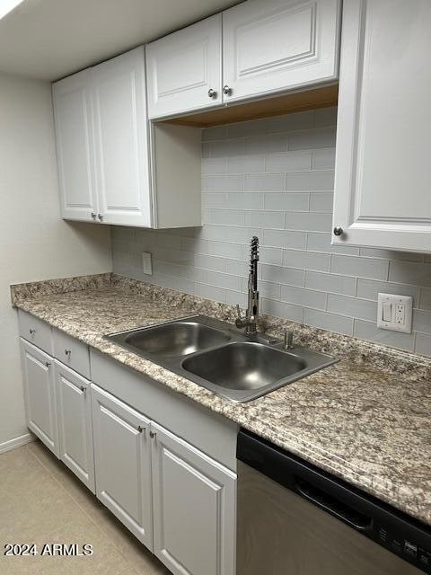 kitchen featuring white cabinets, dishwasher, light tile patterned flooring, and sink