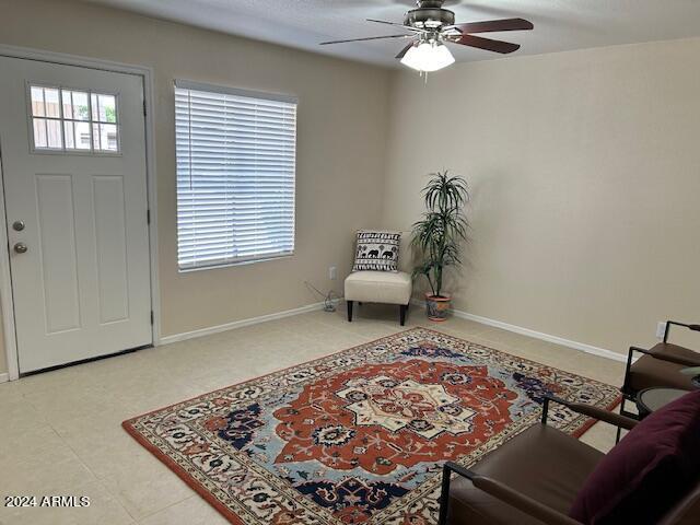 foyer entrance featuring ceiling fan and baseboards