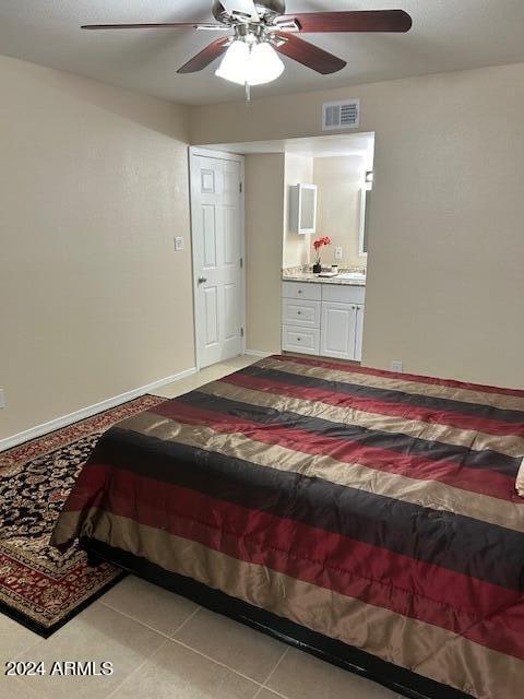 tiled bedroom with ceiling fan and ensuite bathroom