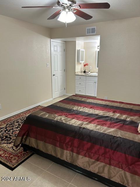 bedroom featuring a ceiling fan, tile patterned flooring, visible vents, and connected bathroom