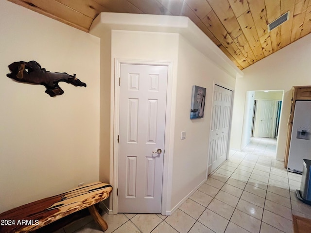 hallway with lofted ceiling, light tile patterned flooring, wood ceiling, and visible vents