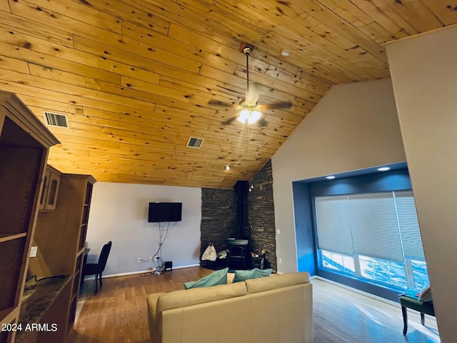 living room featuring wooden ceiling, a wood stove, wood finished floors, and visible vents