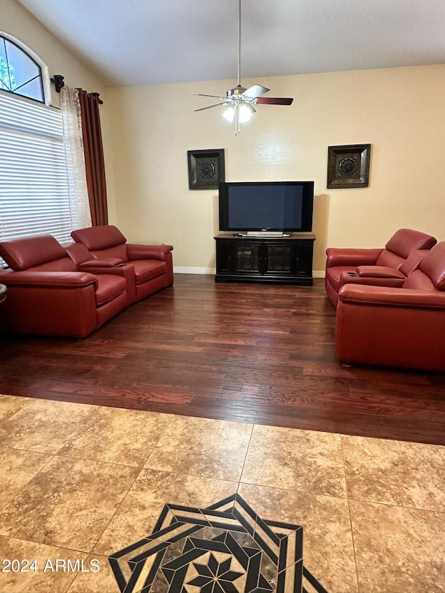 living room featuring dark hardwood / wood-style floors, ceiling fan, and vaulted ceiling