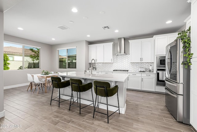 25725 S 230th St, Queen Creek, AZ 85142 - kitchen featuring light countertops, wall chimney range hood, visible vents, decorative backsplash, and appliances with stainless steel finishes